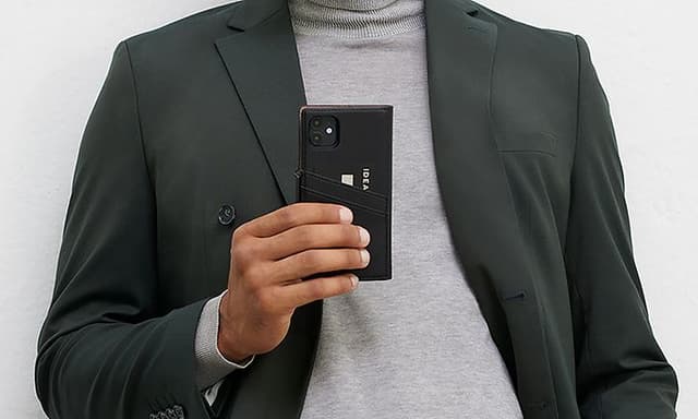 IDEAL OF SWEDEN telefoncover med pung på smartphone holdt af en mand, der poserer