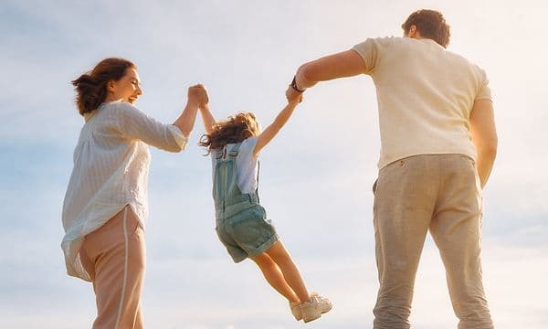 A man and a woman lifting up a child in the air