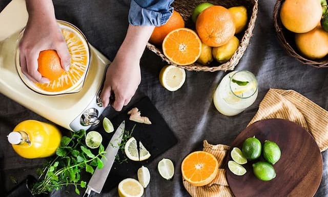 Håndpresser appelsiner på en citruspresse