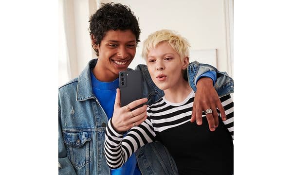 Nainen ja mies ottamassa selfie-kuvaa Samsung Galaxy S21 FE -puhelimella