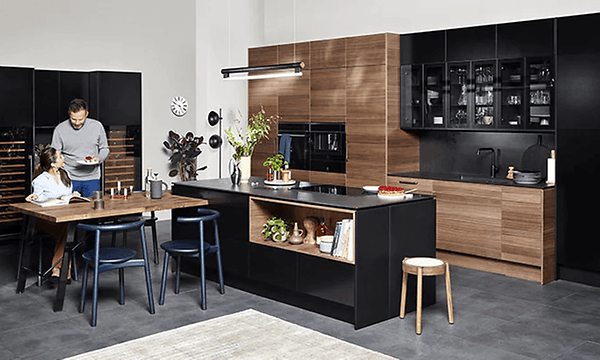 mann serverer kvinne mat i et Epoq Edge-kjøkken i Walnut og Black Ash