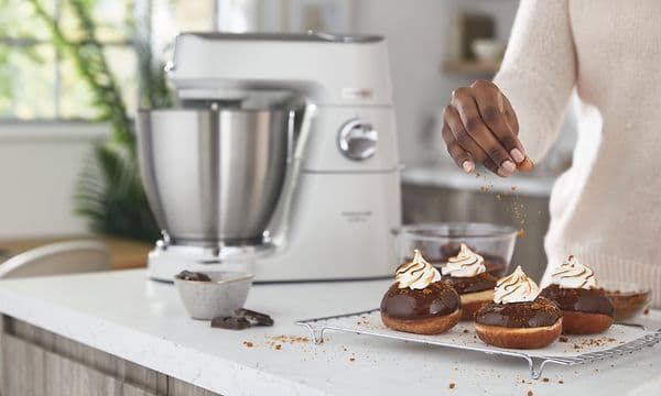 kvinde dekorerer små kager med en Titanium Chef Baker Lite i baggrunden