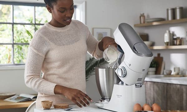 SDA - Kenwood - Kvinde løfter overdelen på en Titanium Chef Baker Lite kitchen machine