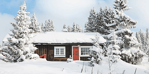 en hytte dekket av snø i et vinterlandskap
