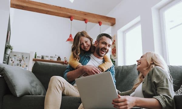 Family using a laptop while laughing