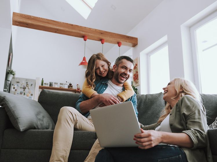 Family using a laptop while laughing