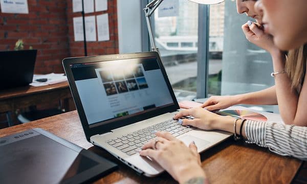 Two women using a laptop to browse the web