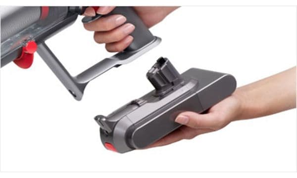 Hand som sätter i ett batteri på Dyson V15.