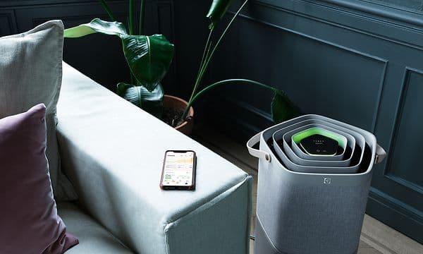  En svart Pure A9 stående ved siden av en sofa med en telefon på toppen
