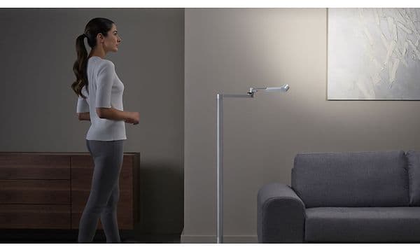 Kvinna som står bredvid en Dyson Lightcycle Morph Floor lampa.