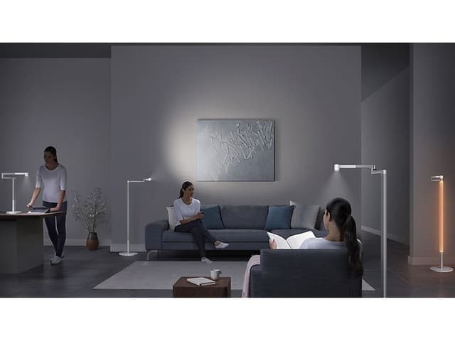 Lightcycle Morph Floor:  Samma kvinna flera gånger i ett vardagsrum med Dyson-ljus.
