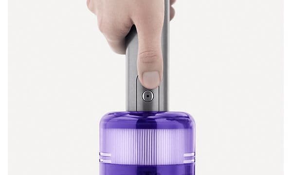 en finger trykker på en-knapps-kontrollen på en Dyson Omni-Glide