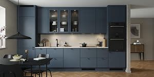Epoq Trend Blue Grey kjøkken i en åpen kjøkkenløsning med integrert stekeovn, vitrineskap og spisebord