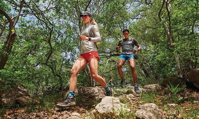 Garmin Fenix 7 på armene til kvinne og mann som løper i terrenget