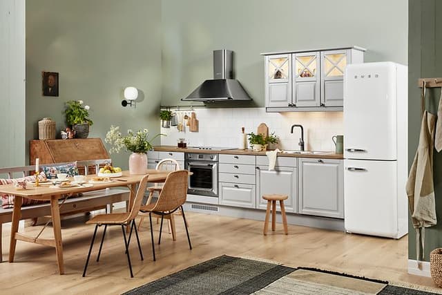 Ljusgrått kök från EPOQ med bänkskiva i trä, köksbord och vitvaror från smeg.
