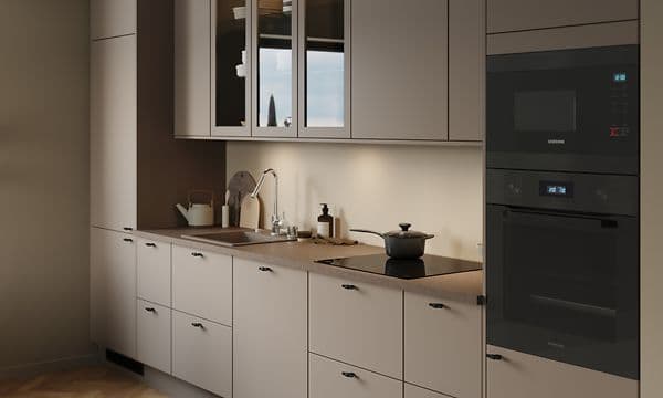 Sandfärgat EPOQ Trend kök med brun bänkskiva, integrerad ugn och micro, vitrinskåp och kran i blank stål.