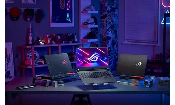 Tre ROG Strix G15 bærbar gaming-PCer oppstilt på et bord i ulike vinkler. 