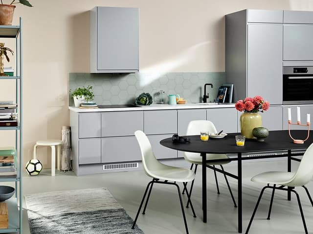 Epoq Integra Light grey kjøkken i en åpen kjøkkenløsning med spisebord, stoler og en bokhylle