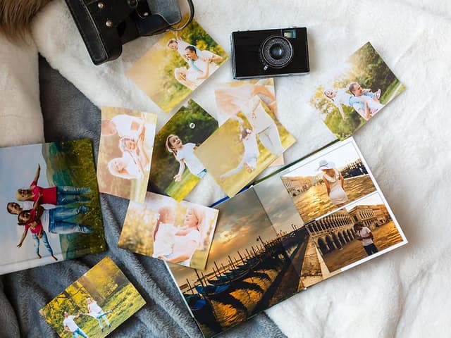 photos, camera and album on a bed
