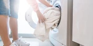 Kvinde tager tøj ud af tørretumbleren
