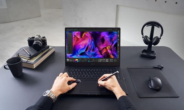 En bærbar asus of to hender som tegner på touchpaden
