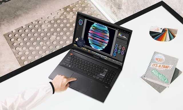 Vivobook Pro og en hånd som trykker på touch-paden