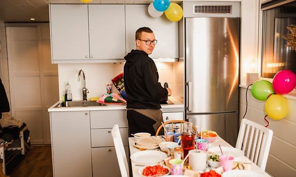 Mand i et lille køkken med kølefryseskab