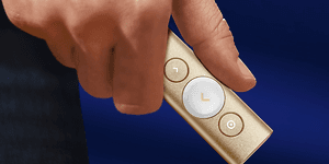 hånd holder Logitech Spotlight presentasjonsfjernkontroll i gull