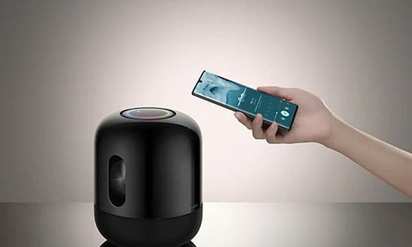 Huawei Sound X portable speaker and hand holding smartphone