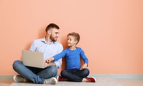 Mies ja poika katselevat yhdessä kannettavaa tietokonetta