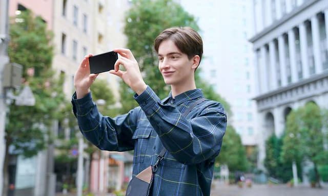 Sony Xperia mobil i hendene på en ung mann i urbant miljø