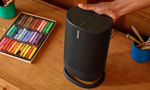 Hånd som løfter Sonos Move fra ladestasjonen