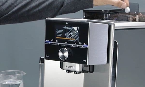 Person putter en rensetablet i Siemens Espresso maskine