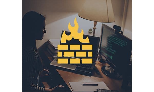 Kvinne foran en datamaskin og et gult brannmursymbol oppå