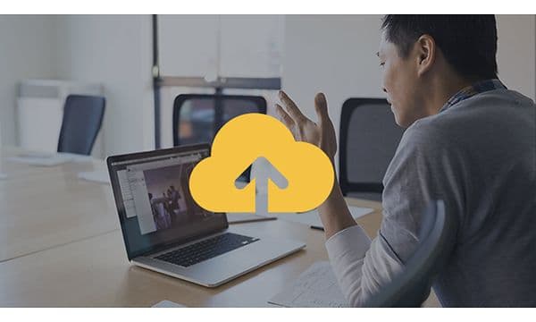 Mann foran en bærbar datamaskin og et gult backup-symbol oppå