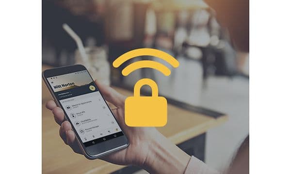 Hånd som holder en smarttelefon og et gult VPN-symbol oppå