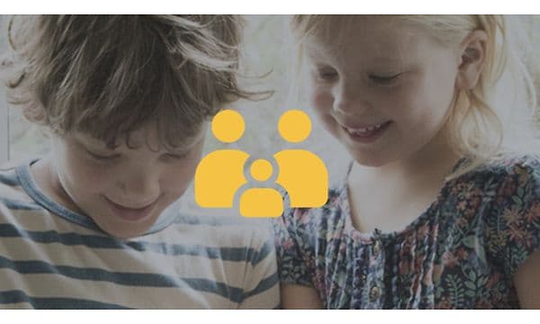 To barn som smiler og et gult familiesymbol oppå