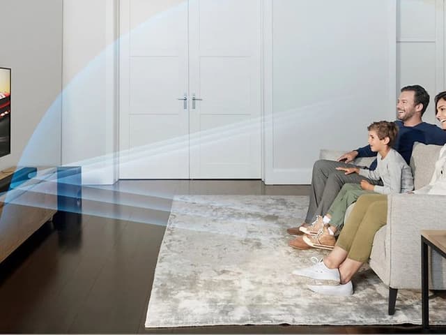 Perhe istuu olohuoneessa ja katsoo yhdessä televisiota Sony soundbarin äänellä