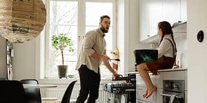Mann som setter inn oppvask i oppvaskmaskinen