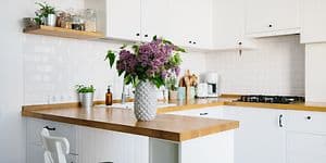 En vase med blomster står på kjøkkenbenken til et lite kjøkken