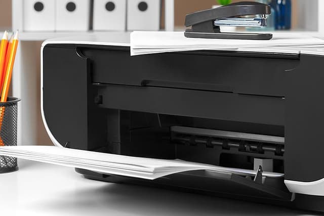 Printer on a desk with pens