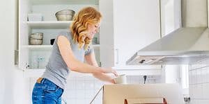 MDA-Frysar-Kvinna packar upp koppar ur en flyttlåda