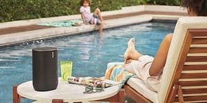 Sonos Move ved en pool på et bord ved siden af en kvinde