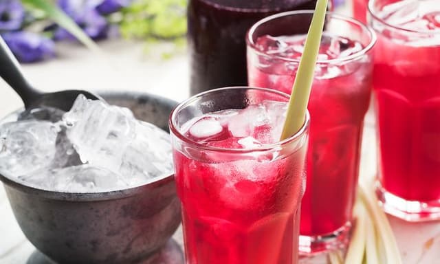 Glass med saft og isbiter på et serveringsbrett