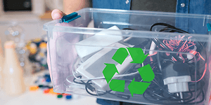 Sustainability - Recycling - A man holding a box with old electronics and a recycle logo