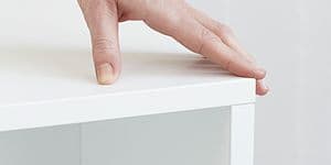 Epoq - Click - Hand pressing down on a white cabinet - Three Spine logo in corner