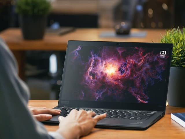 Person sidder på kontor og bruger Lenovo ThinkPad laptop