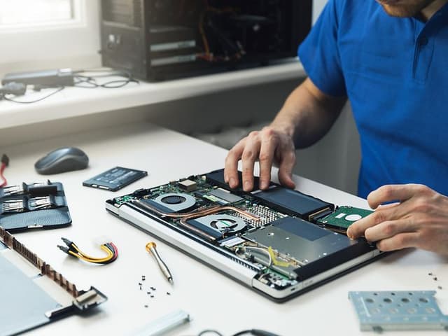 Computing - en mand, der erstatter en SSD på en bærbar computer