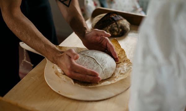 Et par hænder former et brød