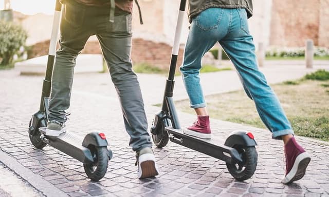 Wearables - Två personer som åker elsparkcykel sedda bakifrån